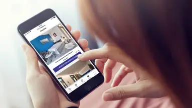Frau hält Handy in der Hand und sieht die App
