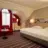 Großes Hotelzimmer mit einem großen Doppelbett und einer Couch vor einem Fenster.