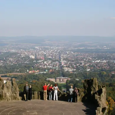 Ausblick auf Kassel vom Bergpark Wilhelmshöhe aus. Mehrere Menschen stehen auf dem Aussichtspunkt.