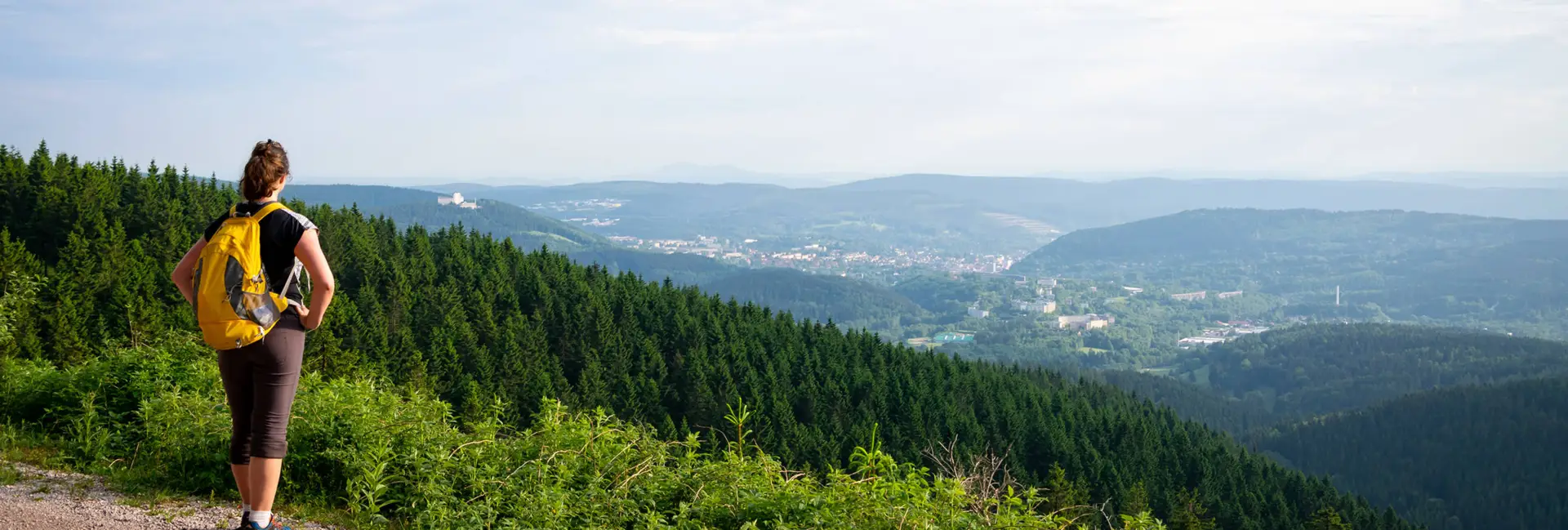 Eine Wanderin blickt über den Thüringer Wald.