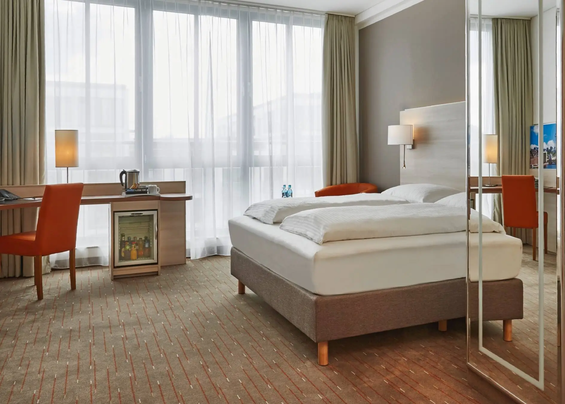 Hotelzimmer mit einem Doppelbett und einem großen Schreibtisch.