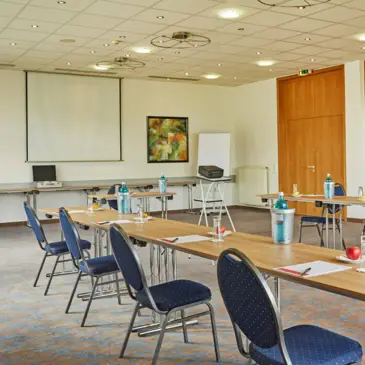 Seminar room with U-shaped seating. A large screen hangs on the wall.