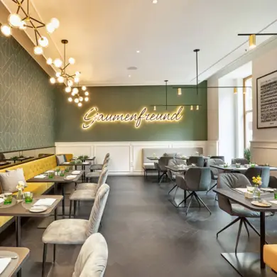 Restaurante Gaumenfreund con pared verde y luz acogedora