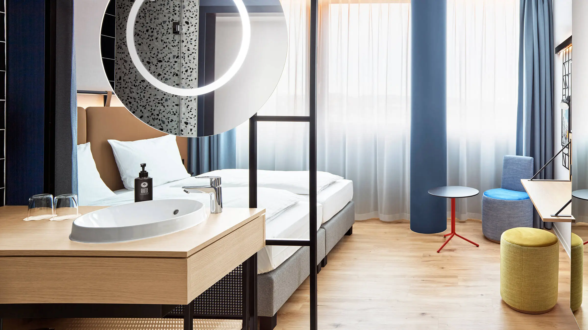 Hotel room with double bed. There is a small sitting area in the middle.