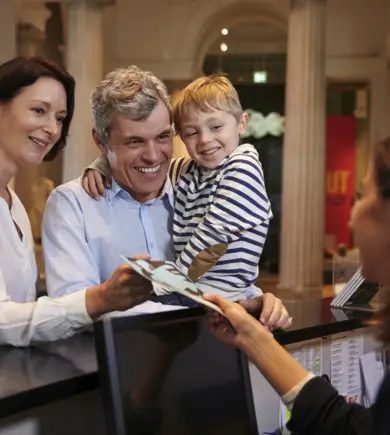 Family visits a museum and stands at the cash desk