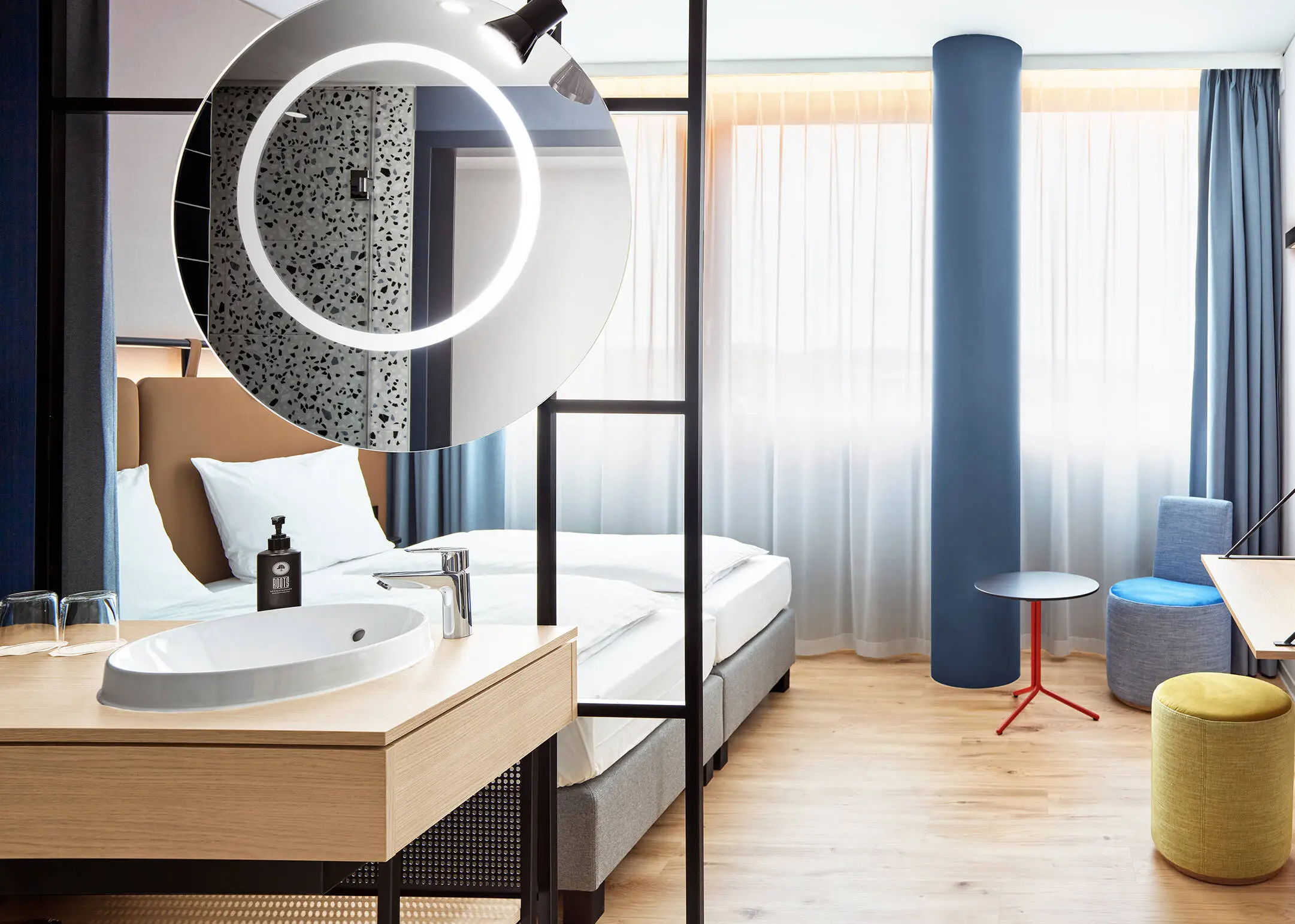 Hotel room with double bed. There is a small sitting area in the middle.