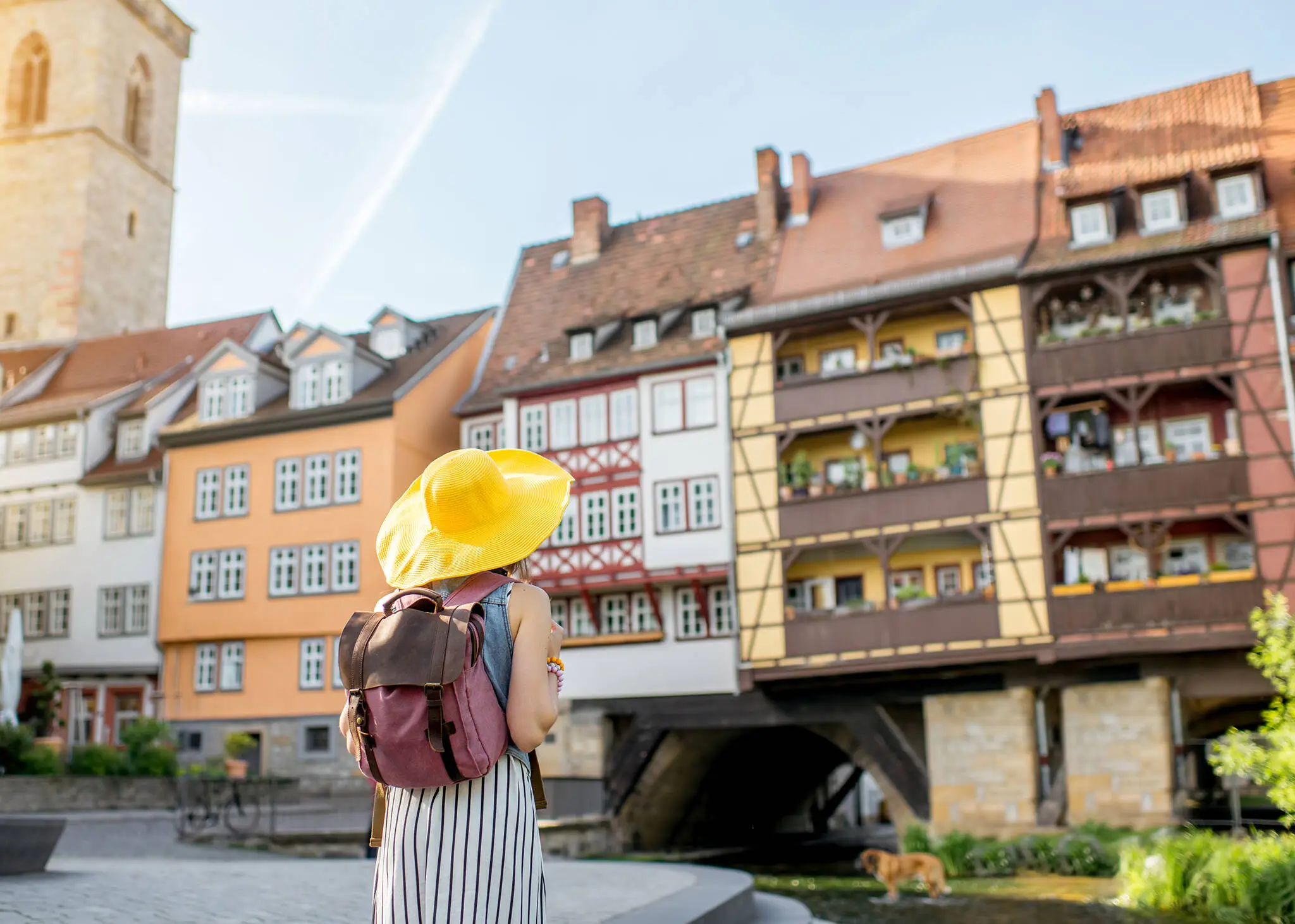 Woman with a yellow sun hat looks at the Krämerbrücke.